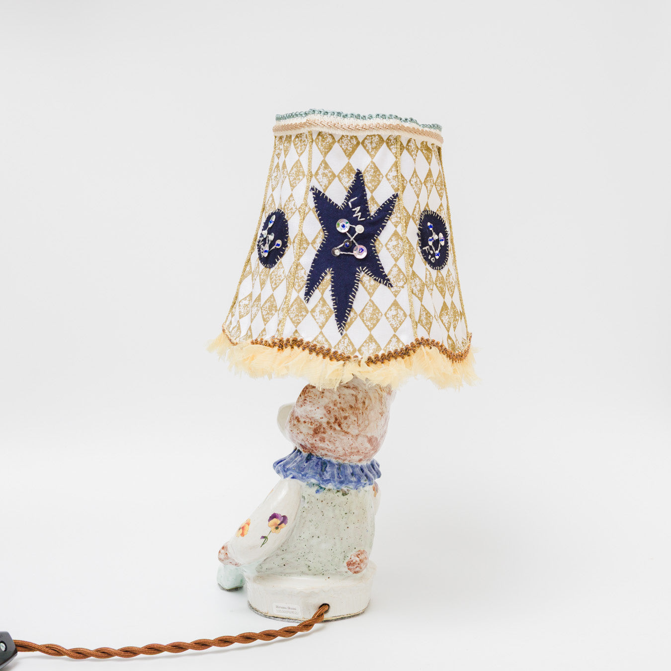 シェードは夜空をイメージし、ぐるりと架空の星々を刺繍とアップリケで表現。スパンコールやビーズのきらめく装飾が、静かに瞬きます。