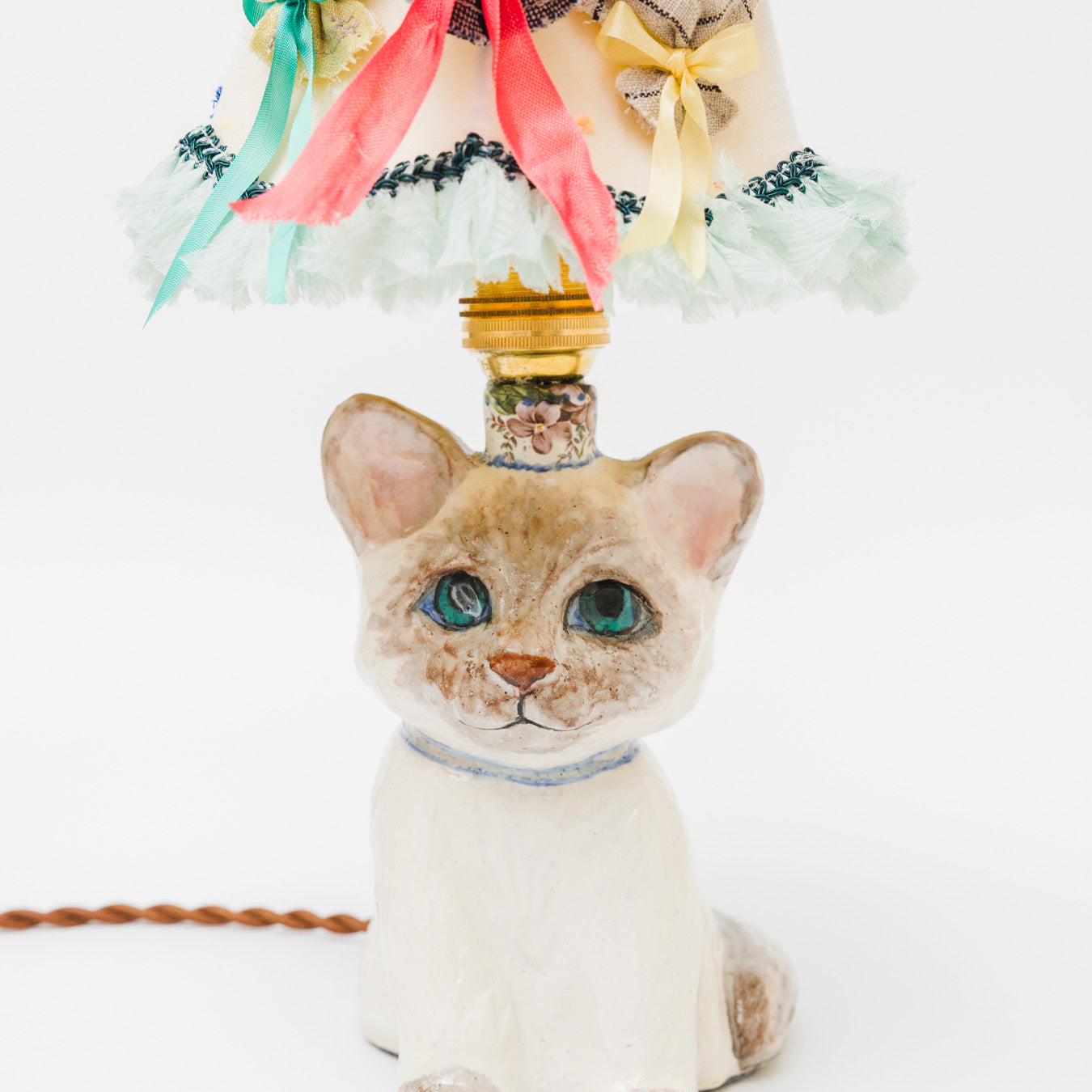 空を見上げるように、ちょこんと座るシャム猫。青い瞳の先には、いつか会いたい魚の夢が浮かんでいます。