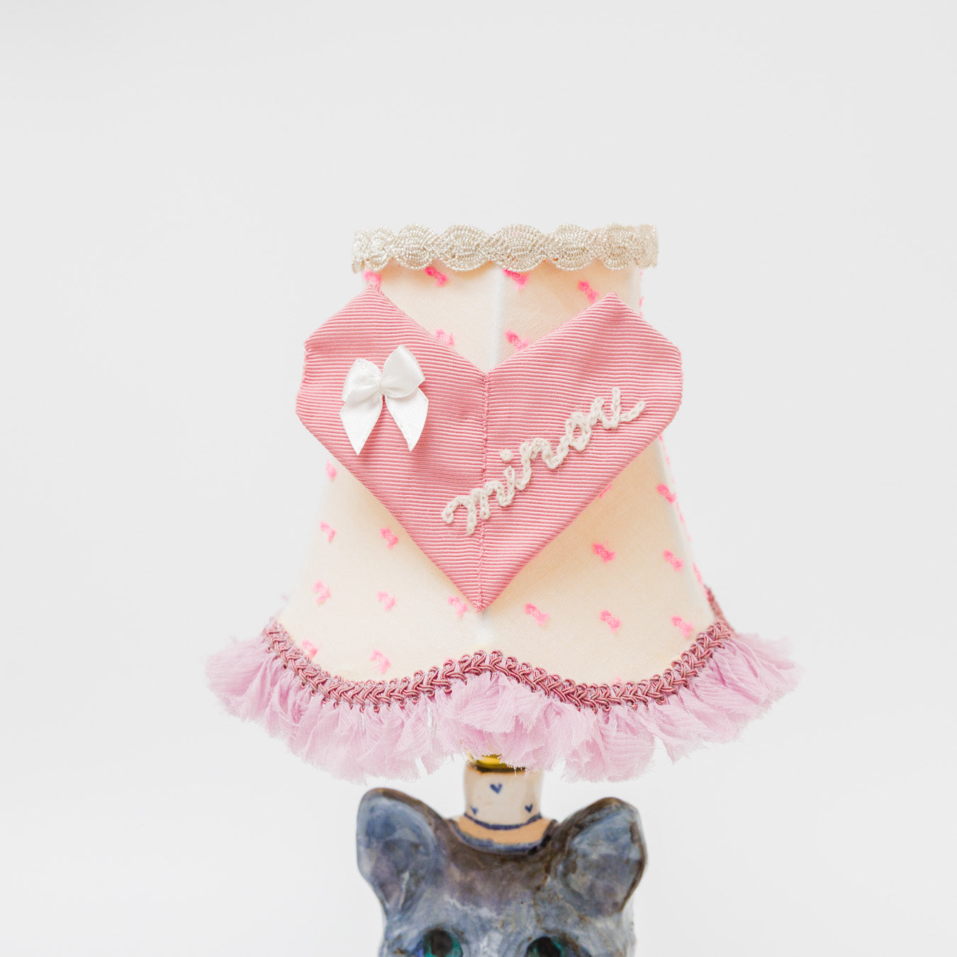 グログランテープを折って仕立てたハートモチーフ。“minou(ミヌー)” はフランス語で「にゃんこ」という、やさしく親しみのある響きの言葉を刺繍しています。