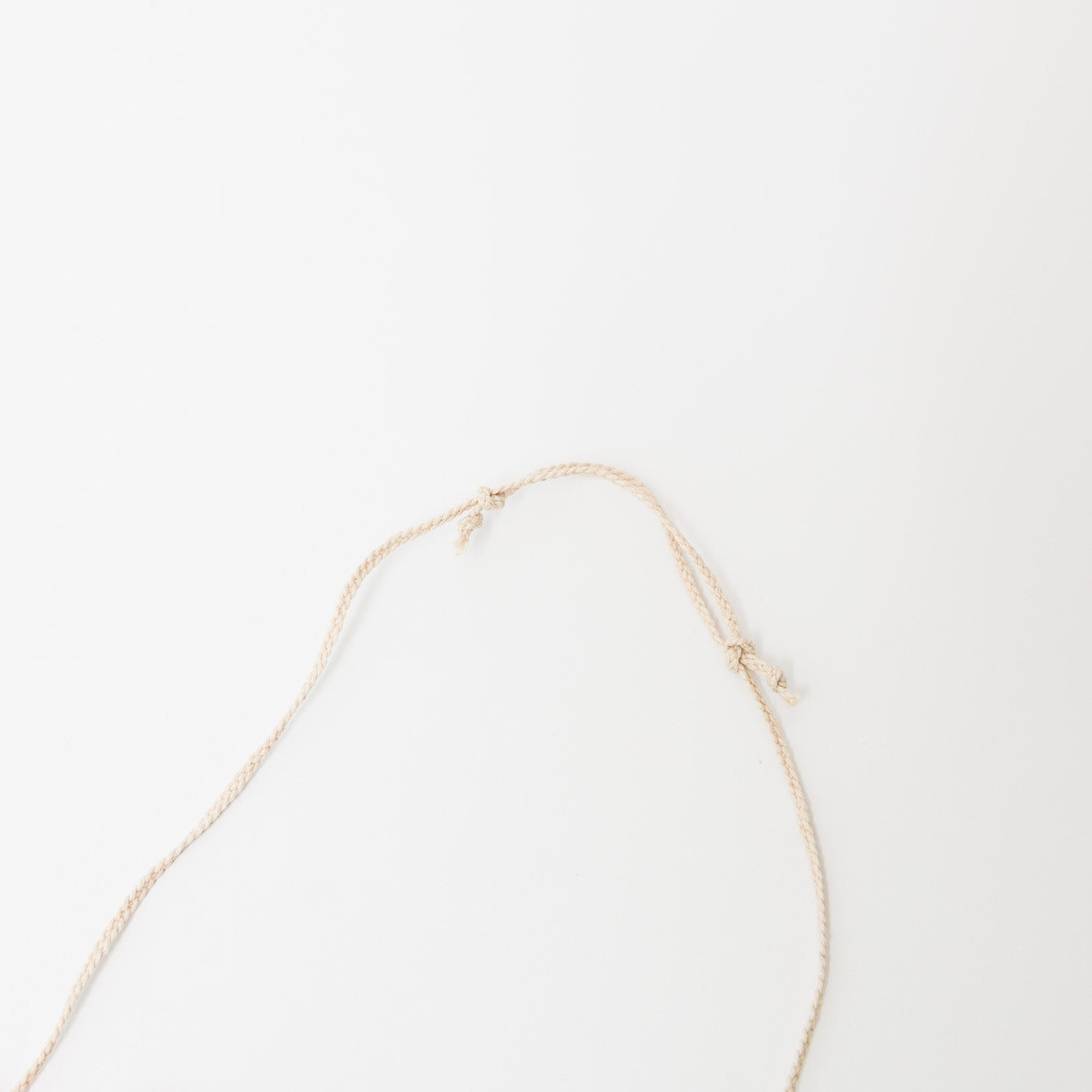 手編みで丁寧に仕立てられた細い麻紐は、長さの調整が可能です。結び目をスライドして調整してください。