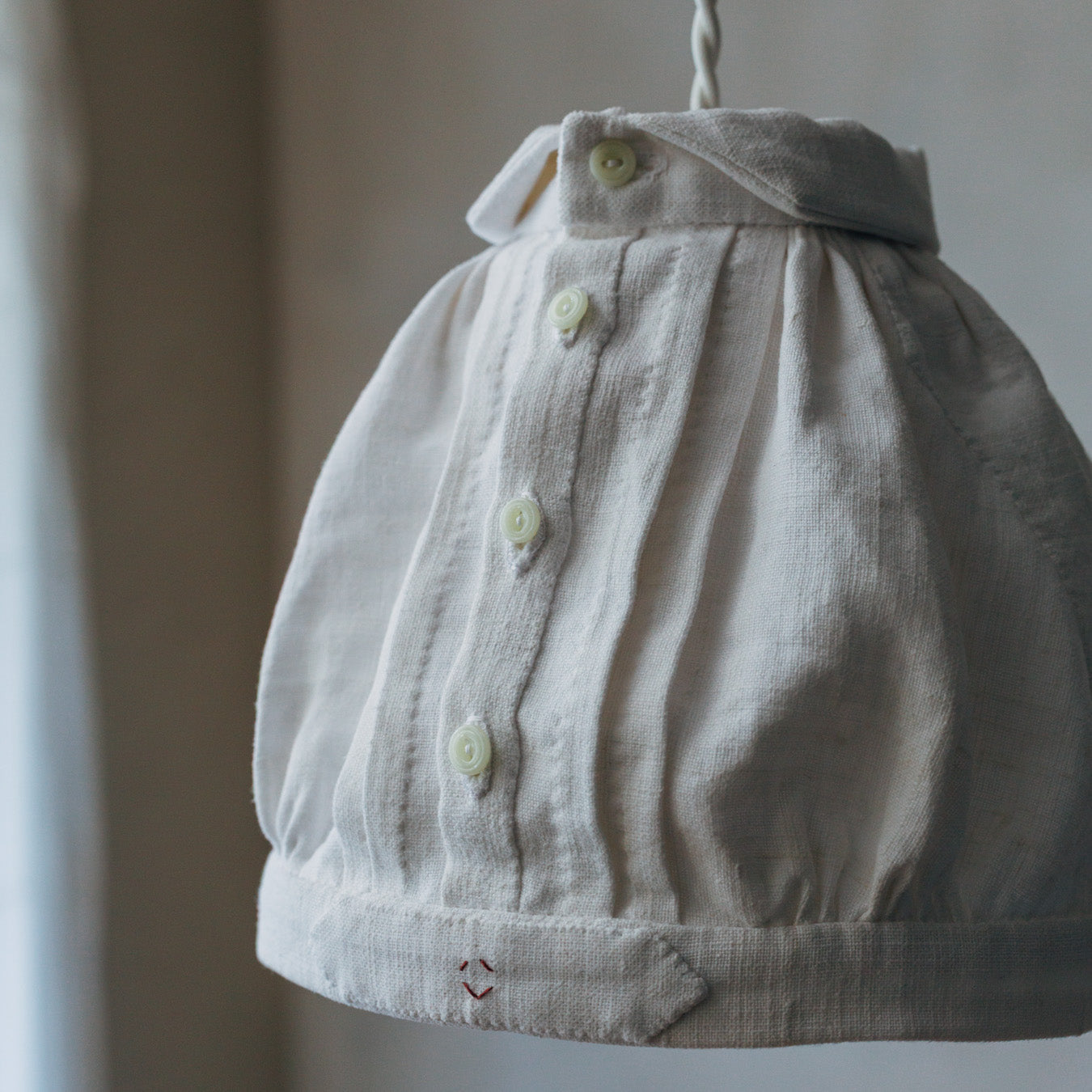 アンティークのフランス製ガラスボタンをあしらっています。手縫いによる仕立ての表情も、魅力のひとつです。