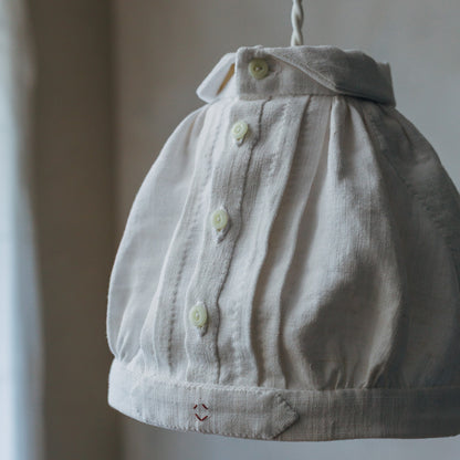 アンティークのフランス製ガラスボタンをあしらっています。手縫いによる仕立ての表情も、魅力のひとつです。