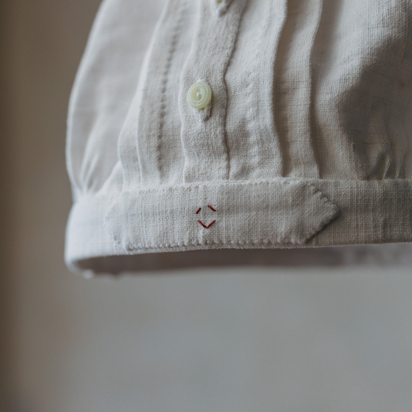 時を経たリネンならではの風合いも魅力。裾タブには、あんこちゃんのワンポイント刺繍。思わず微笑むアクセントです。