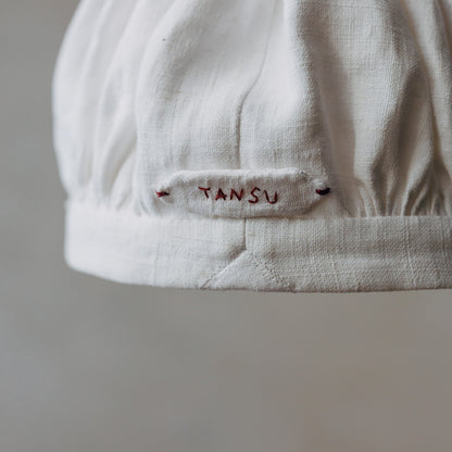 さりげなくあしらわれたTANSU刺繍のタブ。