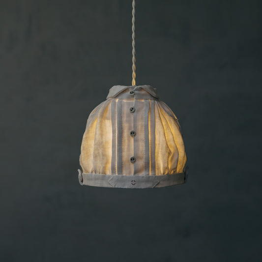 アンティークリネンで仕立てた、お洋服のようなランプシェードです。やわらかな灯りが、リネンのタックやギャザーの陰影を引き立てます。