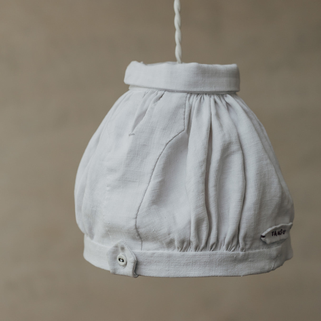 時を経たリネンならではの風合いも魅力。裾には、アクセントとなるタブ仕様のディテール。