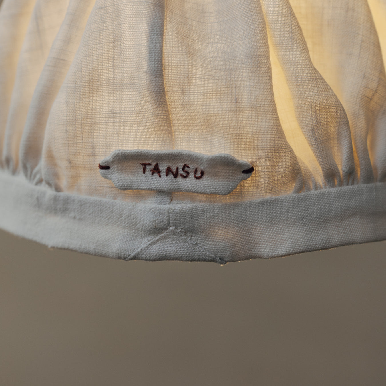 さりげなくあしらわれたTANSU刺繍のタブ。