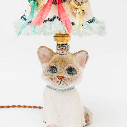 空を見上げるように、ちょこんと座るシャム猫。青い瞳の先には、いつか会いたい魚の夢が浮かんでいます。