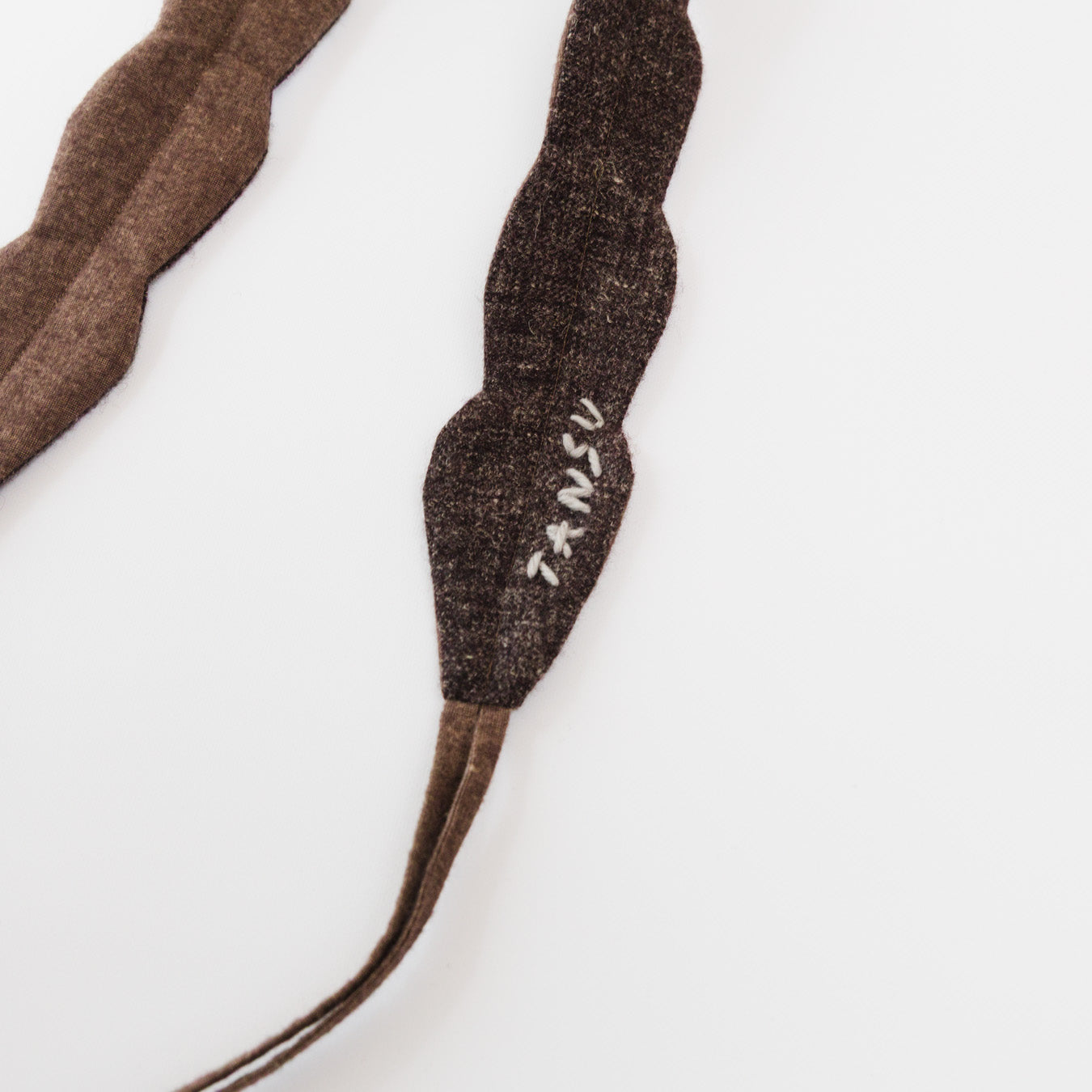 毛糸で施したロゴ刺繍が入っています。