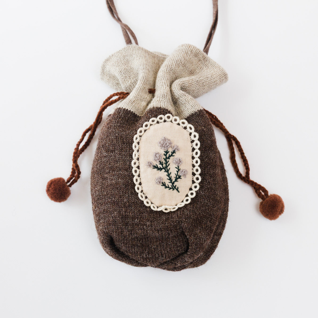 落ち着いたブラウンのニットと、やわらかな生成りのコントラスト。