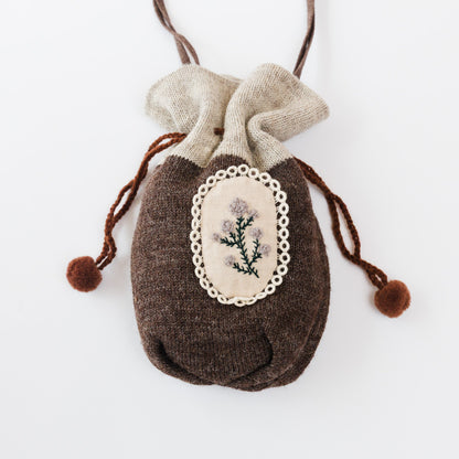 落ち着いたブラウンのニットと、やわらかな生成りのコントラスト。