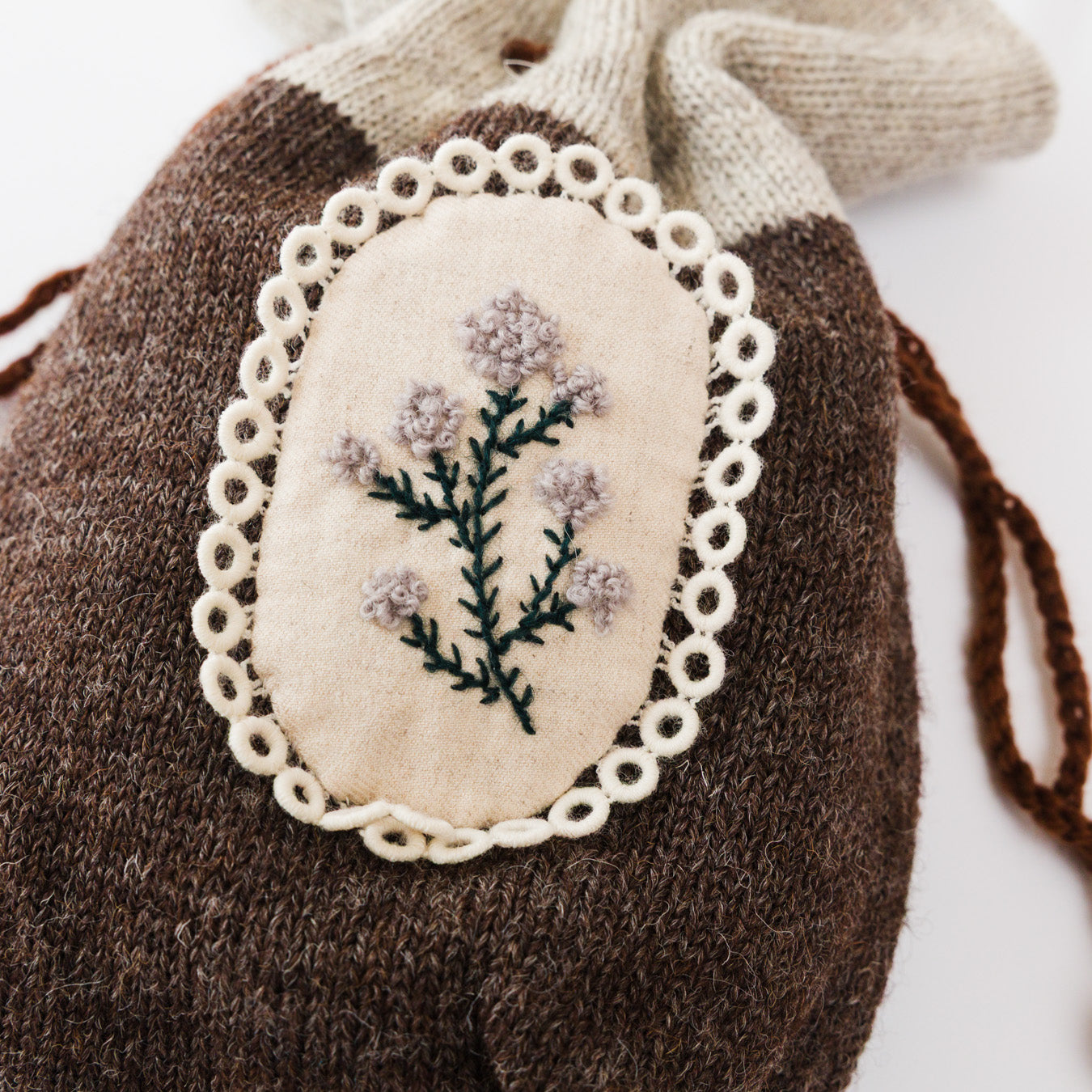 空想草花の刺繍を施した楕円モチーフ。レースの縁取りが小さな標本のよう。