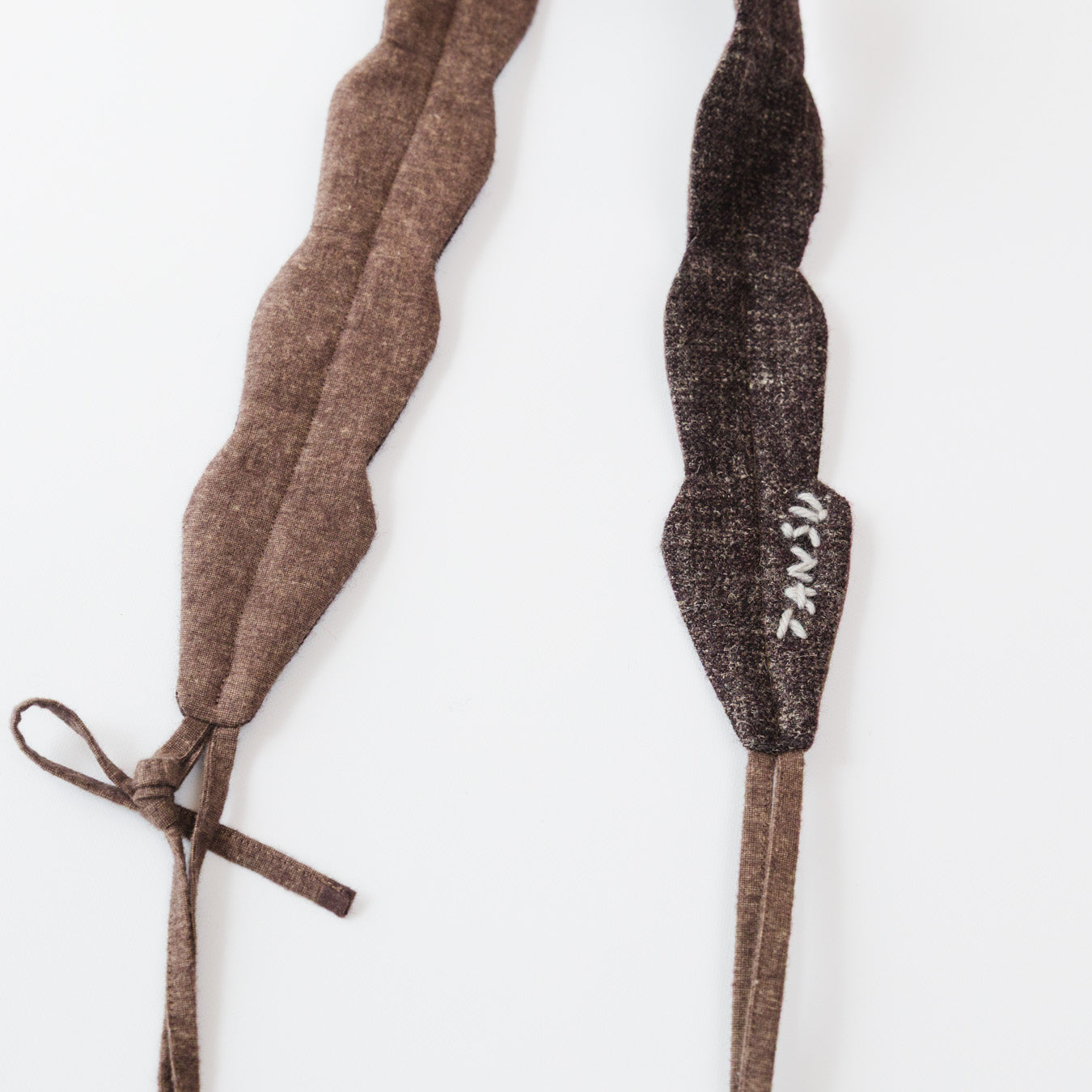 毛糸で施したロゴ刺繍が入っています。